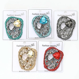 Detail view of five luxury alloy brooches with large crystal stones in multiple colors