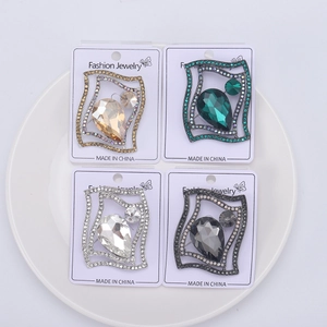 Macro shot of elegant teardrop brooches with colorful rhinestones on display cards
