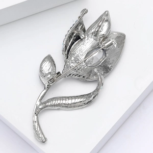 Detail view showing secure silver-toned safety pin clasp and backing of floral brooch