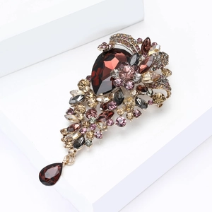 Macro view of vintage crystal brooch with deep red gemstone and intricate golden details