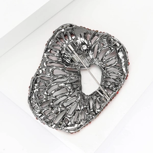 Detail view of the gun black metal back with a safety pin clasp on a luxury brooch