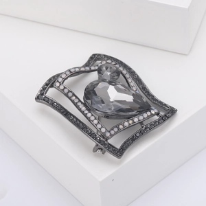 Detailed macro view of gunmetal geometric brooch with teardrop grey crystal inlay