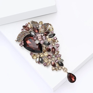 Detailed macro of vintage crystal brooch featuring deep red pear-shaped gemstones