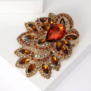 Macro detail of amber crystal flower brooch with gold plating and teardrop gemstone