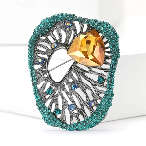 Macro view of vintage style brooch with amber crystal and teal rhinestone details