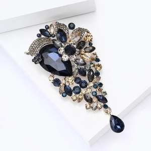 Detailed close-up of a vintage crystal brooch with blue teardrop stones and floral design