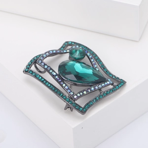Macro view of emerald green teardrop gemstone brooch with black metal plating