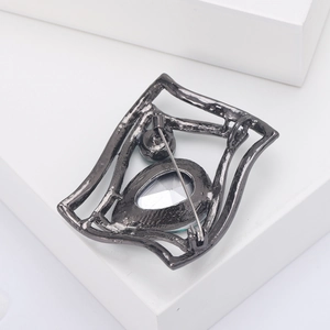 Detail view of the gun black metal brooch back with secure pin and rhinestone settings