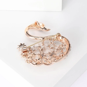 Élégante broche cygne en or rose avec motifs d'étoiles ajourées et fermoir de sécurité