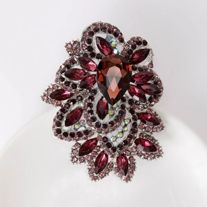 Macro shot of large red pear-shaped crystal brooch with sparkling rhinestone details