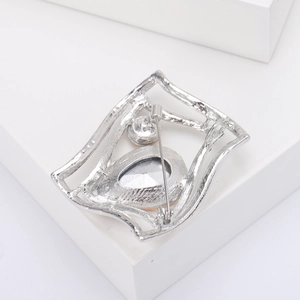 Detail view showing the silver alloy geometric brooch back with a secure safety pin closure
