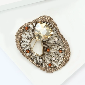 Macro detail of luxury vintage brooch with champagne crystal and rhinestone leaf texture