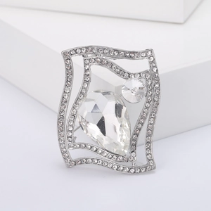 Detailed close-up of a silver brooch with pear-cut crystal and micro-pave rhinestones