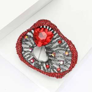 Close-up of vintage gun-black brooch with red triangle gemstone and pave rhinestones