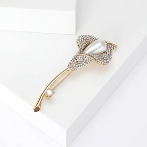 Élégante broche fleur de lys en or avec des strass brillants et une perle en goutte