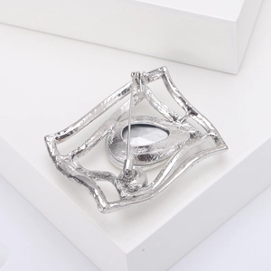 Detail view of the silver brooch back with a secure pin clasp and hammered metal texture