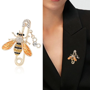 Broche abeille dorée avec ailes en émail et pendentif alvéolé sur revers de veste