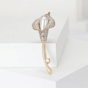 Détail d'une élégante broche de lys calla avec strass arc-en-ciel et perle