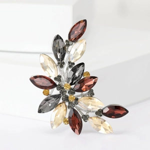 Detailed close-up of crystal leaf brooch with marquise-cut gems in silver setting