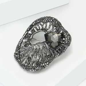 Macro shot of vintage style dark grey alloy brooch with large triangular crystal detail