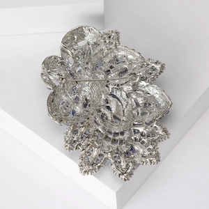 Vintage silver crystal brooch with intricate cutout design and secure back pin closure
