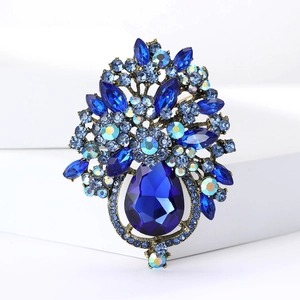 Détail macro d'une broche florale vintage avec un cristal bleu en forme de poire