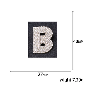Broche lettre B argentée pavée de cristaux avec dimensions de 40 mm sur fond noir