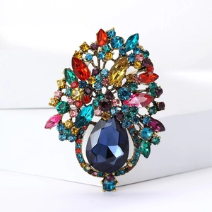 Vue détaillée de broche vintage en alliage avec strass colorés et pierre bleue en poire