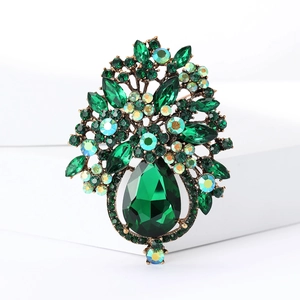 Détail d'une broche fleur vert émeraude avec cristal en poire et base en alliage doré