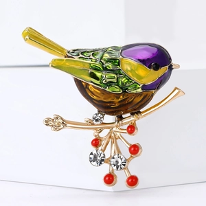 Broche oiseau en émail avec plumes colorées et strass sur une branche dorée élégante