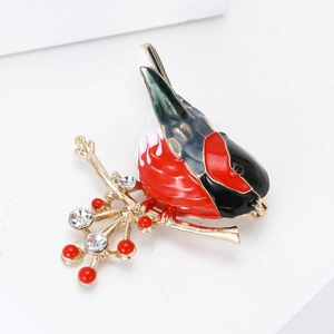 Broche oiseau en émail avec baies rouges et cristaux sur une branche dorée