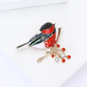 Détail d'une broche d'oiseau plaquée or avec émail coloré et perles décoratives
