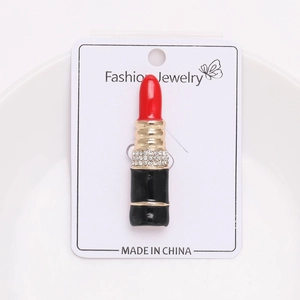 Détail d'une broche rouge à lèvres créative avec émail et cristaux sur carte de support