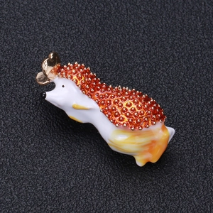 Macro d'une broche hérisson en émail avec cœur doré sur une surface en cuir texturé