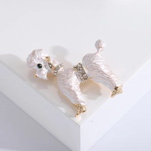 Detail of cute white poodle brooch with green gem eyes and sparkling rhinestone accents