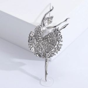 Élégante broche de ballerine argentée avec strass clairs sur un fond blanc minimaliste
