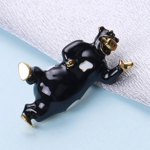 Spilla a forma di mucca in smalto nero e bianco con accenti dorati su sfondo blu