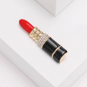 Détail d'une broche rouge en forme de rouge à lèvres avec cristaux et bordure dorée chic