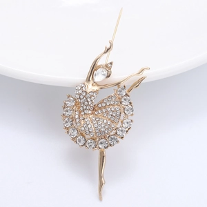 Détail de la broche ballerine dorée avec strass scintillants et design évidé élégant