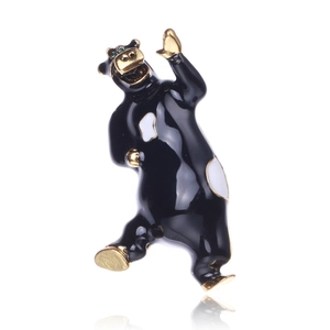 Dettaglio macro della spilla a orso in smalto nero con contorni in metallo dorato lucido