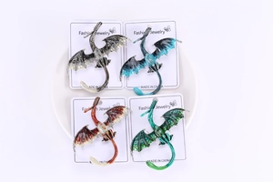 Détail de quatre broches dragon en émail coloré avec textures d'ailes détaillées