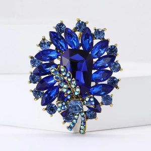 Close-up of vintage blue crystal flower brooch with antique gold alloy and rhinestones