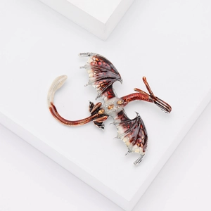 Détail macro d'une broche dragon en émail marbré rouge avec des bordures en métal argenté