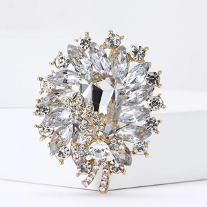 Macro shot of an elegant gold floral brooch featuring a large rectangular crystal center