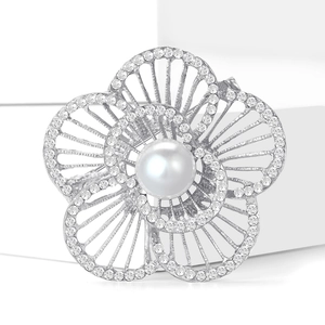 Nahaufnahme der Perlenblumen-Brosche mit Strass-Einlagen auf weißem Display