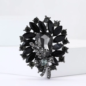 Macro view of crystal flower brooch with grey stones and gunblack plated petals