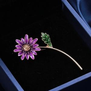 Détail d'une broche tournesol en émail violet avec tige dorée et petits cristaux
