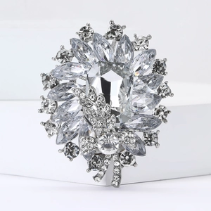 Detailed macro view of silver crystal flower brooch with emerald cut center stone
