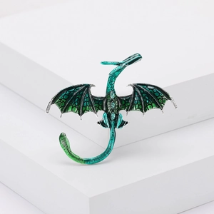 Broche dragon vert en alliage argenté avec émail et cristaux sur un socle blanc épuré
