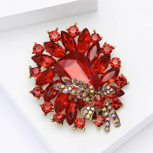 Macro view of crystal brooch featuring large red rectangular stone and copper base